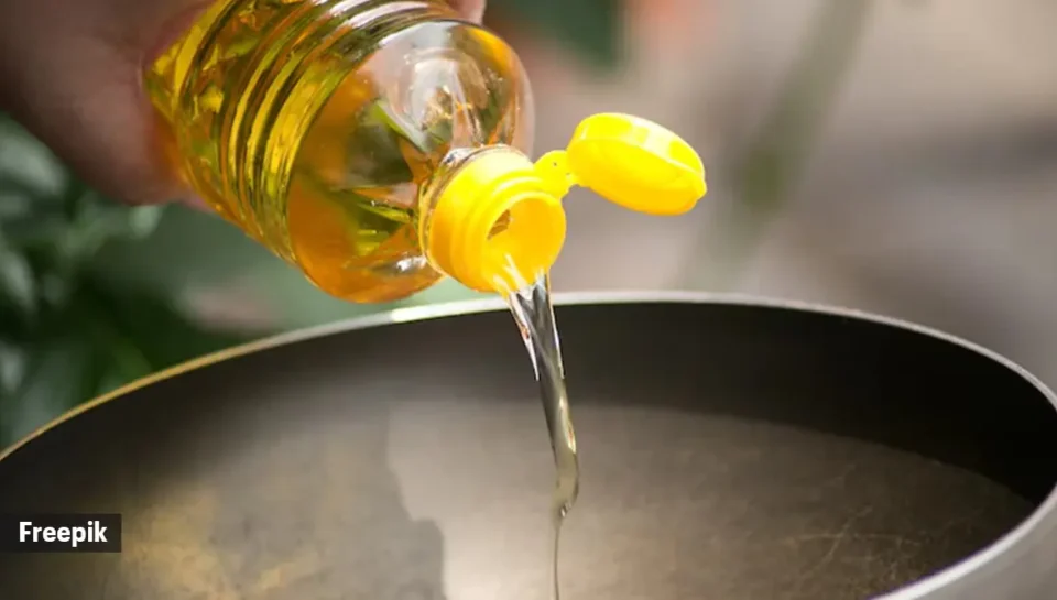 A person pouring kitchen soul oil into a pan